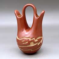 A red wedding vase carved with an avanyu design around the body
 by Vickie Martinez of Santa Clara