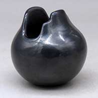 A small black jar with a geometric cut opening, click or tap to see a larger version