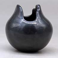 A small black jar with a geometric cut opening, click or tap to see a larger version