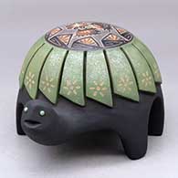 A polychrome turtle figure carved with a feather design and decorated on top with a sgraffito hummingbird, flower and geometric design plus inlaid stones
 by Melony Gutierrez of Santa Clara