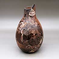 A sepia jar with an organic opening and decorated with a sgraffito hummingbird, branch, leaf and flower design
 by Bernice Naranjo of Taos
