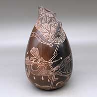A brown jar with an organic opening, an applique fold and decorated with a sgraffito sea serpent, ocean wave and geometric design
 by Bernice Naranjo of Taos