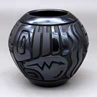 A matte and polished black jar decorated with a four-panel carved spiral, bear, feather and geometric design
 by Harrison Begay Jr of Santa Clara