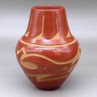 A red jar decorated with a carved avanyu and geometric design around the shoulder and carved feather design around the neck
 by Sherry Tafoya of Santa Clara