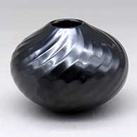 A small black jar decorated with a spiraling facet design from top to bottom
 by Denny Gutierrez of Santa Clara