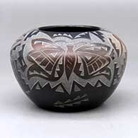 A black bowl decorated with sienna spots and a sgraffito hummingbird, butterfly and geometric design
 by Candelaria Suazo of Santa Clara