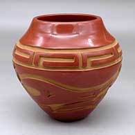 A red jar carved with an avanyu and geometric design around the body
 by Sherry Tafoya of Santa Clara