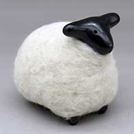 A highly polished black sheep figure in a coat of white wool
 by Joe and Eunice Naranjo of Santa Clara