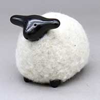 A highly polished black sheep figure in a coat of white wool
 by Joe and Eunice Naranjo of Santa Clara