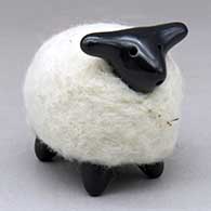 A highly polished black sheep figure in a coat of white wool
 by Joe and Eunice Naranjo of Santa Clara