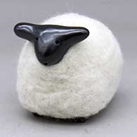 A highly polished black sheep figure wearing a coat of white wool
 by Joe and Eunice Naranjo of Santa Clara