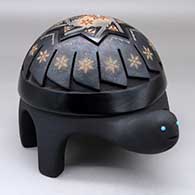 A polychrome turtle figure with sienna spots and decorated with a carved and sgraffito feather, flower, hummingbird and geometric design, plus three inlaid stones
 by Melony Gutierrez of Santa Clara