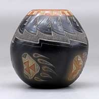 A small black jar with a sienna rim and spots and decorated with a sgraffito bear paw, knife edge and geometric design, click or tap to see a larger version
