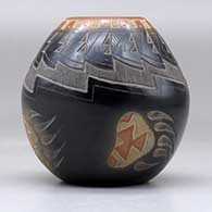 A small black jar with a sienna rim and spots and decorated with a sgraffito bear paw, knife edge and geometric design, click or tap to see a larger version