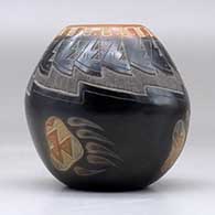 A small black jar with a sienna rim and spots and decorated with a sgraffito bear paw, knife edge and geometric design, click or tap to see a larger version