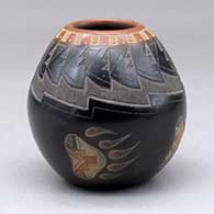 A small black jar with a sienna rim and spots and decorated with a sgraffito bear paw, knife edge and geometric design
 by Justin Naranjo of Santa Clara