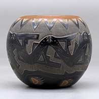A small black bowl with a sienna rim and spots and decorated with a sgraffito avanyu, bear paw and geometric design, click or tap to see a larger version