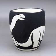 A black on white jar with an organic rim and decorated with a dinosaur design
 by William Pacheco of Santo Domingo