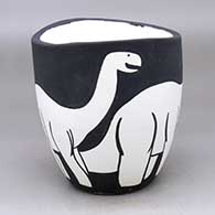 A black on white jar with an organic rim and decorated with an allosaur design
 by William Pacheco of Santo Domingo