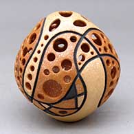 A golden micaceous seed pot with cutouts, light carving and a geometric design
 by Hubert Candelario of San Felipe