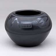 A black on black bowl decorated with a butterfly, feather and geometric design above the shoulder
 by Marvin and Frances Martinez of San Ildefonso