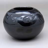 A black on black bowl decorated with an avanyu and geometric design above the shoulder
 by Anita Martinez of San Ildefonso