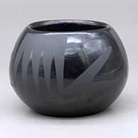 A black on black jar decorated with a three-panel bat wing and geometric design
 by Santana Martinez of San Ildefonso