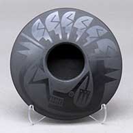 A black on black bowl decorated with an avanyu and feather design above the shoulder
 by Marvin and Frances Martinez of San Ildefonso
