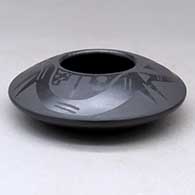 A black on black bowl decorated with an avanyu and pueblo design above the shoulder, click or tap to see a larger version