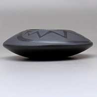 A black on black bowl decorated with an avanyu and pueblo design above the shoulder, click or tap to see a larger version