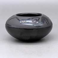 A black on black bowl decorated with an avanyu and geometric design above the shoulder
 by Marvin and Frances Martinez of San Ildefonso