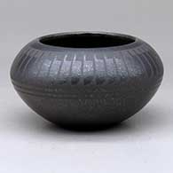 A black on micaceous black bowl decorated with a band of feathers above the shoulder
 by Johnny Cruz of San Ildefonso