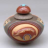 A lidded polychrome jar decorated with a lightly carved bear, geometric sgraffito design, strings of inlaid heishi beads and multiple inlaid stones
 by Russell Sanchez of San Ildefonso