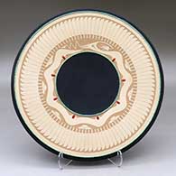 A black and buff plate decorated with a sgraffito avanyu, band of feathers and geometric design, two inlaid strands of heishi beads and nine inlaid stones
 by John Gonzales of San Ildefonso
