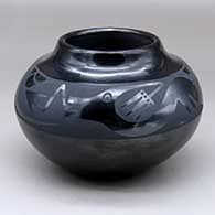 A black on black jar decorated with an avanyu and geometric design around the shoulder
 by Santana Martinez of San Ildefonso