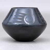 A black on black jar decorated above the shoulder with a four-panel bat wing, spiral and geometric design, click or tap to see a larger version