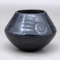 A black on black jar decorated above the shoulder with a four-panel bat wing, spiral and geometric design
 by Maria Martinez of San Ildefonso