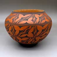 A black-on-red jar decorated with an eight-panel geometric design
 by Anderson Jamie Peynetsa of Zuni