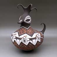 A polychrome duck effigy pot with a feathered crown and decorated with a deer-with-heart-line and geometric design
 by Anderson Peynetsa of Zuni