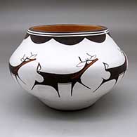 A polychrome jar decorated around the body with a deer with heart line and geometric design
 by Anderson Peynetsa of Zuni