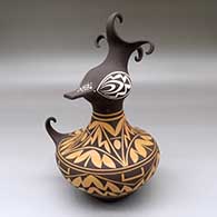 A polychrome duck effigy with a feathered crown and decorated with a four panel geometric design
 by Anderson Jamie Peynetsa of Zuni