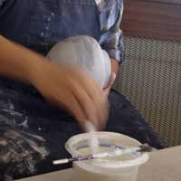 Applying the white slip with a piece of cloth